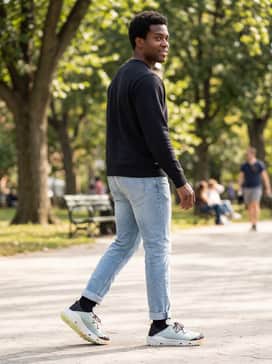 Ua Kilchis River – Light-wash tapered jeans with a neat cuff, a simple black crewneck sweatshirt, and a baseball cap for a casual urban look.