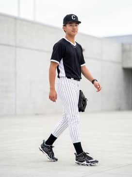 Ua Leadoff Icon Mid – A full team uniform featuring white pinstriped baseball pants, a black moisture-wicking jersey, and a matching black-and-white embroidered team cap.