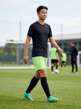 A full performance soccer kit featuring a black moisture-wicking jersey and electric lime green shorts to echo the boot's vibrant sole.