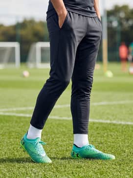 A sleek all-black training outfit consisting of a compression base layer, tapered track pants, and lime-accented crew socks for a professional look.