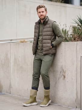 Water-resistant olive joggers with a matching technical quarter-zip pullover and a lightweight down-insulated puffer vest for a functional look.