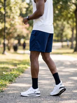 A summer-ready active look consisting of breathable navy mesh shorts, a white performance tank top, and sleek black sunglasses.