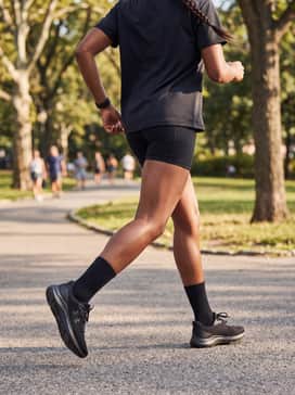 Black biker shorts combined with an oversized graphic t-shirt and mid-calf crew socks to lean into a trendy, retro-inspired athletic aesthetic.