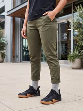 Style with olive green tapered joggers, a white fitted tee, and an open lightweight black bomber jacket for a modern athletic vibe.