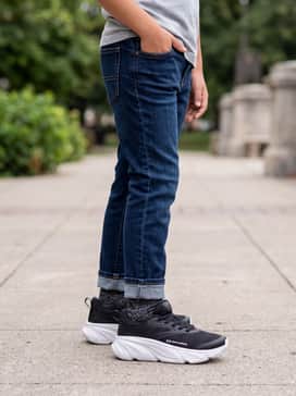 Ua Rogue 6 Al – Dark wash slim-fit jeans rolled at the cuff with a grey heathered graphic hoodie for a clean, back-to-school look.