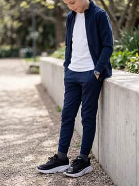 Tapered navy blue joggers combined with a matching tracksuit jacket and a simple white cotton tee underneath.
