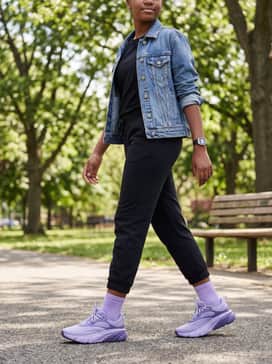 A street-style inspired look pairing black oversized joggers with a cropped graphic t-shirt and a vintage-wash denim jacket for a comfortable yet fashionable weekend outfit.