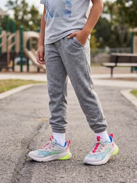Tapered heather grey joggers and a graphic tee with blue accents, layered under a lightweight black zip-up hoodie for a cool streetwear vibe.