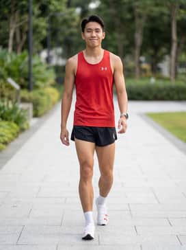 A sleek red performance racing singlet paired with black aerodynamic split shorts and ultra-thin white technical socks for a classic competition look.