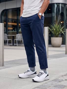 A weekend casual ensemble with slim-fit light wash denim, a crisp white crewneck sweatshirt, and a navy blue baseball cap.