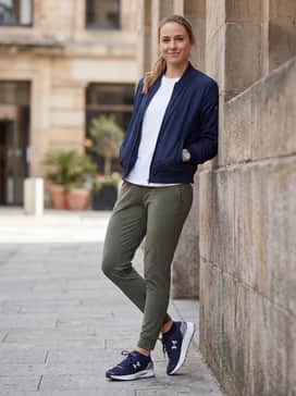 Ua Speedform Gemini – A laid-back weekend outfit consisting of tapered olive green joggers, a basic white crew-neck t-shirt, and a navy blue nylon bomber jacket to complement the shoes' primary color.
