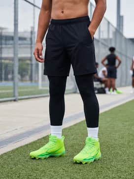 Black moisture-wicking athletic shorts paired with a grey compression shirt and white crew socks to let the neon shoes stand out during drills.