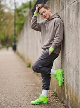 Ua Spotlight Hammer – Tapered charcoal joggers with a neutral oversized hoodie and lime green wristbands for a stylish post-game look that maintains the athletic vibe.