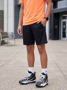 Ua Spotlight Hammer Jr Wide – Black mesh training shorts paired with a neon-colored moisture-wicking t-shirt and a matching sports headband for high-intensity practice.