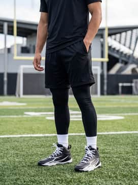 Ua Spotlight Hammer Wide – Performance training gear consisting of black compression leggings, lightweight mesh athletic shorts, and a dry-fit technical tee.