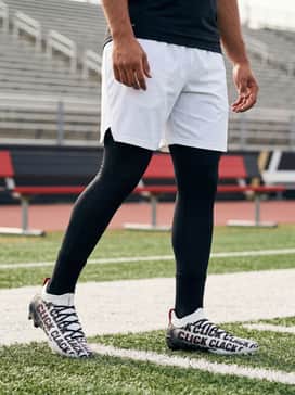 Ua Spotlight Pro Click Clack – Black high-compression leggings paired with white moisture-wicking shorts and a sleeveless performance top for intensive summer training drills.