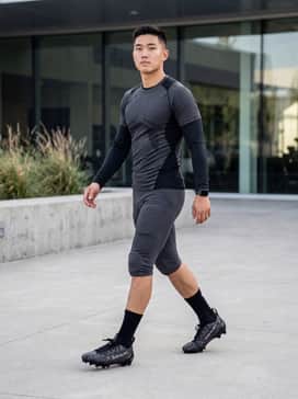 Ua Spotlight Pro Pth – A complete game-day kit featuring a compression-fit team jersey, integrated padded football pants in a matching dark hue, and high-performance black crew socks.