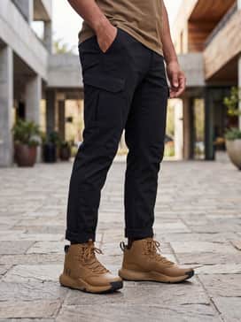 Ua Stellar Mid – Tapered black joggers paired with an oversized sand-colored hoodie and a black bomber jacket for an urban streetwear aesthetic.