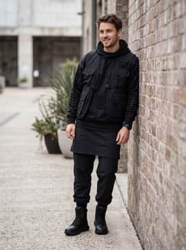 Matte black nylon joggers with an oversized black graphic hoodie and a multi-pocket utility vest for a modern, functional techwear outfit.