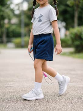 Ua Surge 4 Ac – A sporty ensemble featuring navy blue mesh athletic shorts, a matching light-grey moisture-wicking graphic t-shirt, and white crew socks for a coordinated look.
