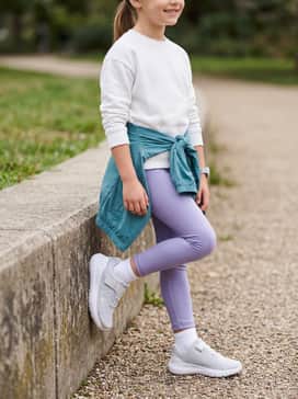 An active play look with lavender performance leggings, a white racerback tank top, and a lightweight teal zip-up windbreaker for outdoor adventures.