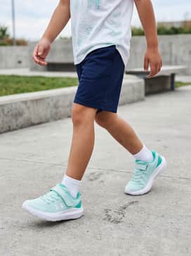 Ua Surge 4 Ac Running – A pair of navy blue mesh athletic shorts paired with a vibrant white graphic T-shirt featuring a subtle teal print to match the shoes.