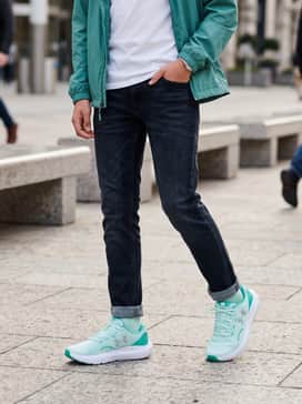 Ua Surge 4 – A classic school-day look with dark-wash slim denim jeans, a crisp white polo shirt, and a lightweight teal windbreaker.