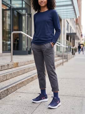 Ua Surge – Slim-fit light wash cropped denim jeans with a tucked-in oversized white graphic tee and a navy blue baseball cap for a relaxed weekend outing.