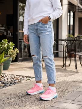 Ua Turbulence 3 – Style with light-wash distressed mom jeans and a simple white crewneck sweatshirt, letting the bright pink of the shoes serve as a bold pop of color for a casual day out.