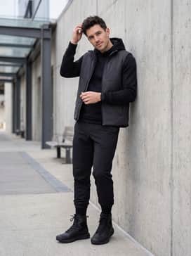Ua Valsetz Waterproof Zip – For a modern athletic aesthetic, wear black performance joggers with a cinched ankle, a black compression hoodie, and a lightweight insulated vest in a dark grey finish.