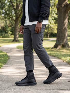 A street-casual style with charcoal grey chino pants, a clean white heavyweight crewneck tee, and a black nylon bomber jacket to balance the boot's heavy silhouette.