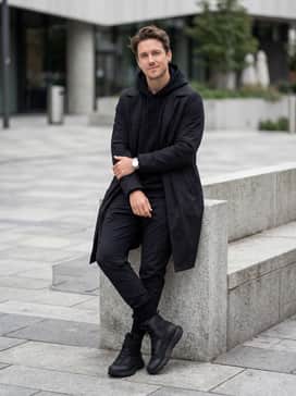 Ua Valsetz Wide 4e – A modern techwear ensemble with black tapered utility joggers, an oversized graphic hoodie, and a long waterproof trench coat.