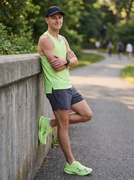 Ua Velociti Elite 3 – Summer Sprint: A neon lime performance tank top that echoes the shoe's primary color, paired with charcoal grey 5-inch running shorts and a breathable black sports cap.
