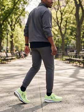 Tech-savvy street style: Style with slim-fit dark denim rolled at the cuff, a black graphic t-shirt, and a neon-accented windbreaker for a cohesive, modern urban outfit.