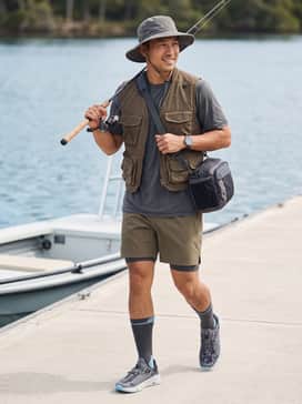 A moisture-wicking charcoal performance t-shirt paired with olive green cargo shorts and a wide-brimmed fishing hat.