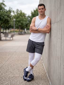 A breathable summer practice look consisting of charcoal mesh athletic shorts and a white moisture-wicking training tank top.