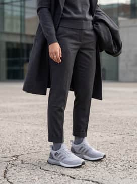 Dark-wash tapered denim jeans cuffed at the ankle, a simple white crewneck tee, and a beige trench coat for a sophisticated yet comfortable city stroll ensemble.