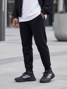 Ultraboost 5 Strung Shoes – An urban streetwear ensemble with tapered black tech-fleece joggers, a crisp oversized white t-shirt, and a minimalist black bomber jacket.
