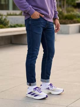 Slim-fit tapered indigo jeans matched with an oversized vintage University of Washington sweatshirt in heathered purple for a classic gameday aesthetic.