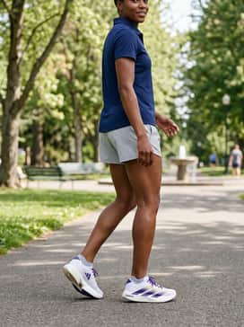 Lightweight navy blue athletic shorts worn with a breathable light grey performance polo and white no-show socks for a clean, sporty summer vibe.