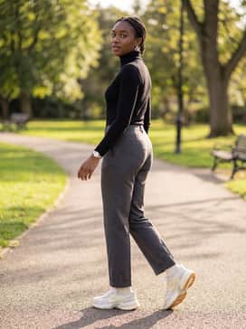 V2k Run – Straight-leg charcoal trousers with a tight-fitting black turtleneck and silver jewelry to complement the sneaker's metallic details.