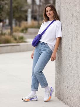 Velocity Nitro 4 Goretex Womens – A casual weekend outfit consisting of light-wash straight-leg jeans with a cuffed hem, a crisp white oversized graphic tee, and a purple crossbody bag.