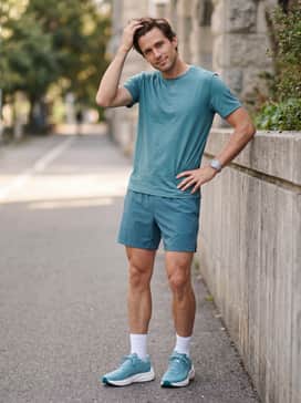 Style with breathable 5-inch inseam black running shorts, a matching teal moisture-wicking tee, and low-profile white athletic socks to emphasize the shoe's sleek design.