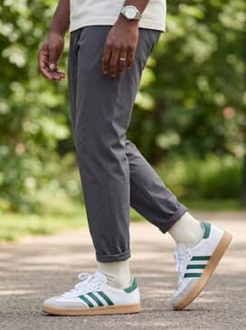 Black technical joggers, a charcoal grey oversized hoodie, and a baseball cap for a relaxed, streetwear-inspired weekend ensemble.