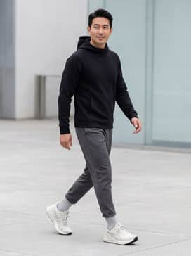 A pair of charcoal grey tapered joggers paired with a fitted black tech-fleece hoodie for a streamlined gym-to-street look.