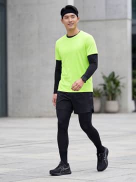 Versablast 4 Wide – High-performance look: Black compression tights layered under lightweight 5-inch running shorts, paired with a neon moisture-wicking tech tee for visibility and a matching sweatband.