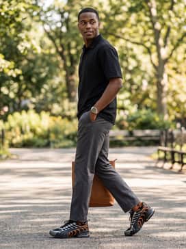 Voltra Mens Sneakers – A clean urban style consisting of straight-leg charcoal chinos, a crisp black polo shirt, and a metallic-finish sports watch to complement the sneaker's silver overlays.