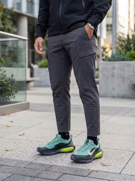 Vomero 18 Goretex – Tapered charcoal grey tech cargo pants, a black GORE-TEX waterproof shell jacket, and a dark teal performance beanie for a functional urban look.