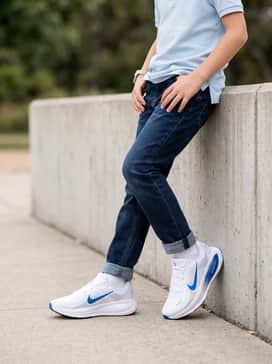 Style with dark-wash tapered jeans and a light-colored polo shirt for a smart-casual school day ensemble that stays functional.