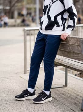 A school-ready look consisting of tapered navy blue track pants and a high-contrast graphic hoodie in white and black.